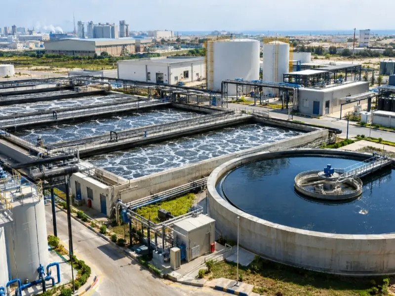 Industrial wastewater treatment site with aeration tanks, a circular clarifier and storage tanks